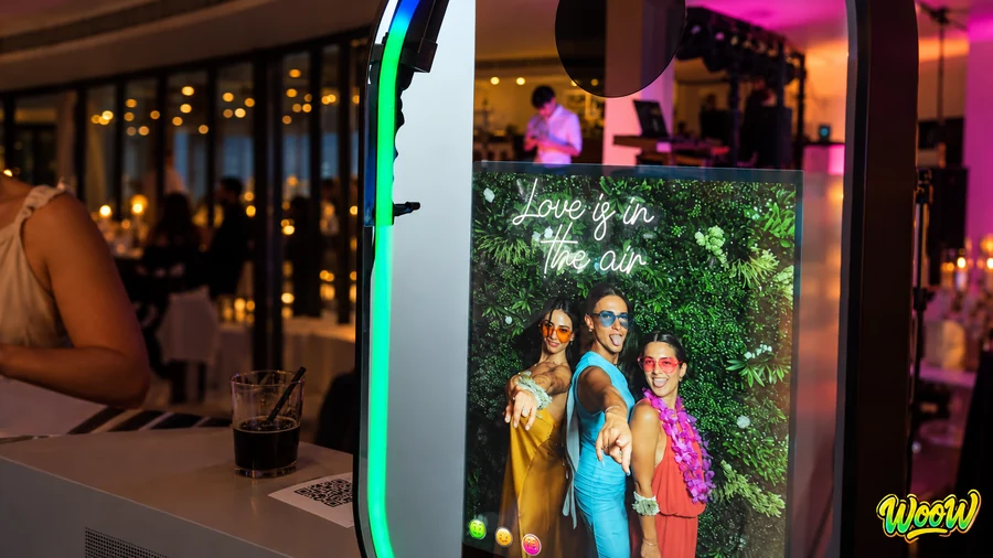 Inicio Pantalla del fotomatón WooW con la foto recién hecha de tres invitadas y el aro de luz encendido