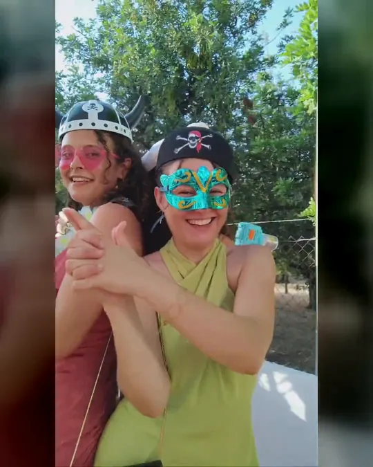Invitados con sombreros, pelucas y gafas de fiesta grabando su vídeo en el videomatón 360 de WooW en un evento al aire libre